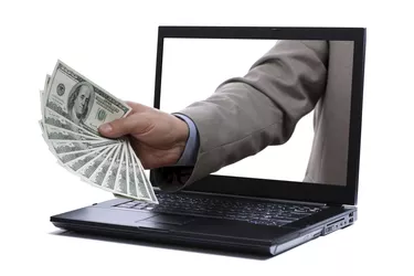 Dollar bills through a laptop screen