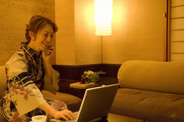 Woman talking on a mobile phone and using a laptop