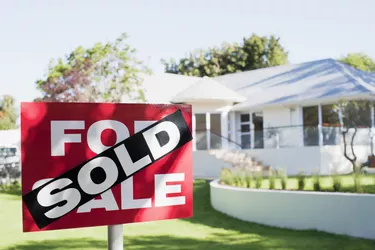 Sold sign in front yard of house