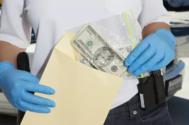 Police Officer Putting Money in Evidence Envelope