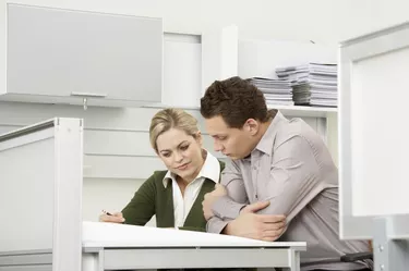 Businessman and businesswoman working at desk in office
