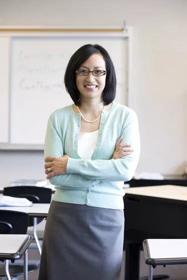 Teacher smiling in classroom, portrait