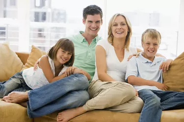 Family sitting in living room smiling