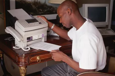 Man removing paper from fax machine