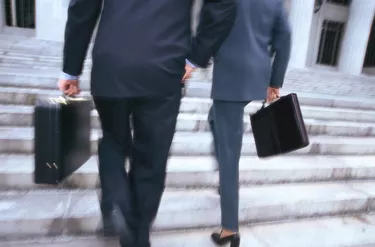 business executives with briefcases climbing stairs
