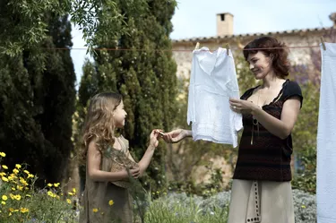 Mother and daughter (8-9) hanging laundry in garden