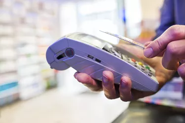 Man paying with NFC technology on credit card, in pharmacy