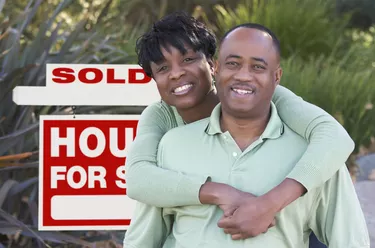 Happy Couple and Real Estate Sign