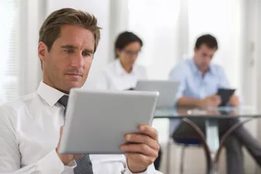Businessman using his digital tablet in the office
