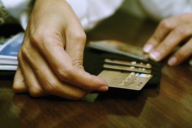 Person's hand taking out a credit card from a wallet