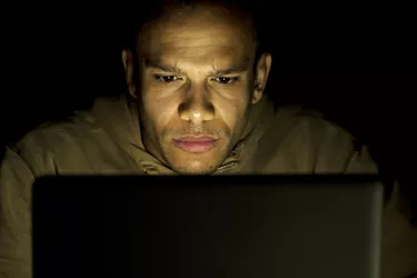 Concentrating man on his laptop at night