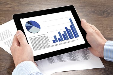 businessman holding a tablet with graphics on screen