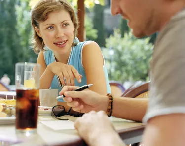 Couple having drink at outdoor cafe (focus on woman)