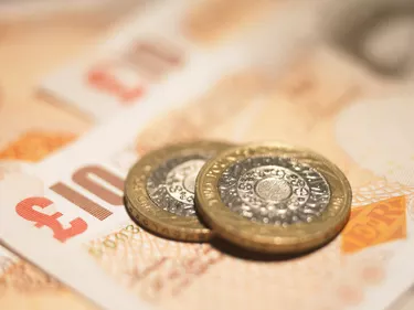 British Currency: Two pound coins on ten pound banknotes, close-up