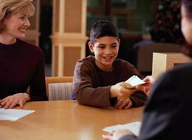 Boy Giving Paper Currency to a Financial Advisor