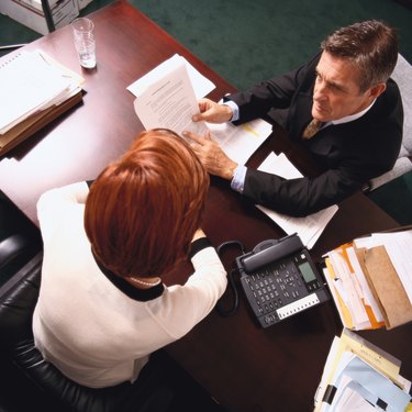 high angle view of a businessman explaining a document to a woman associate