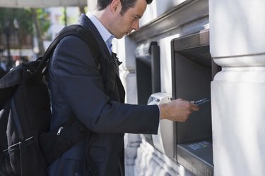 Businessman getting money from ATM machine