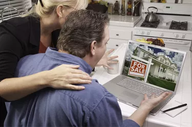 Couple In Kitchen Using Laptop - Real Estate