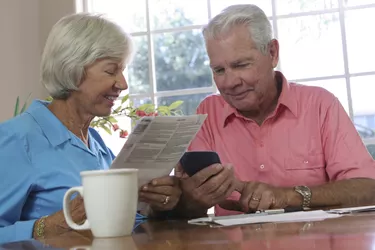 Close-up of a senior couple looking at a calculator