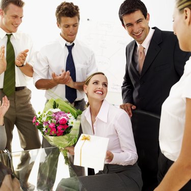 businesswoman presented with flowers and a gift