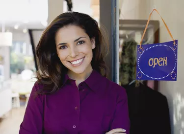 Gift shop owner with open sign in window