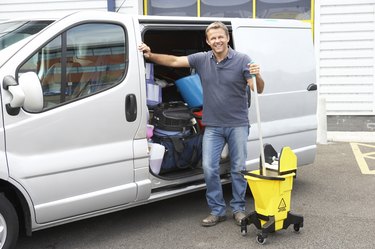 Cleaner standing next to van