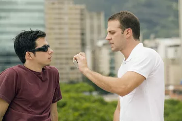 Side profile of a mid adult man talking to a young man