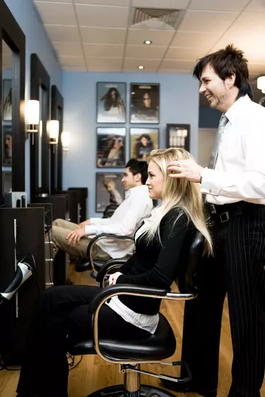 Hair stylist with client in beauty salon