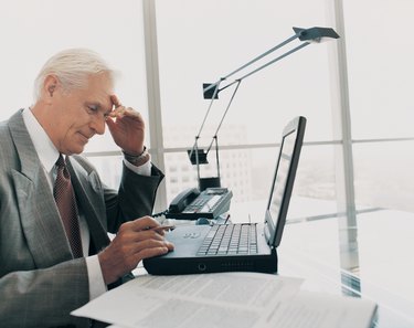 Mature Businessman Working at His Desk on a Laptop in the Office