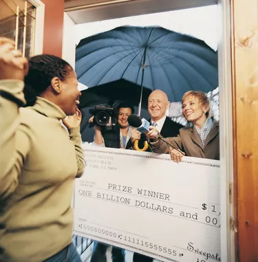 Broadcasters Present a Cheque to an Ecstatic Woman in her Home