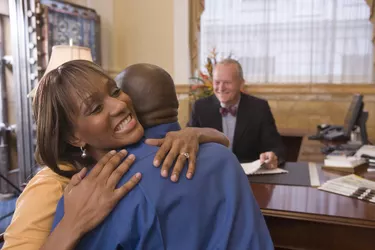 Couple embracing while meeting with loan officer