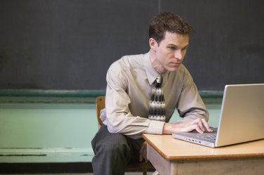 Teacher with laptop in classroom
