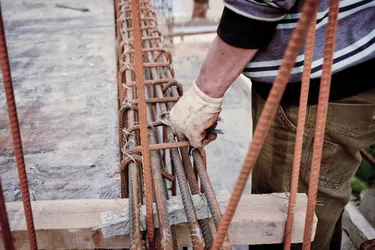 builder workers installing metal rods bars into framework reinfo