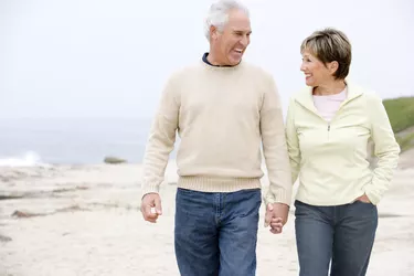 Couple at the beach holding hands and smiling