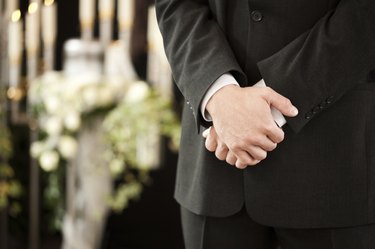 man or mortician at funeral mourning