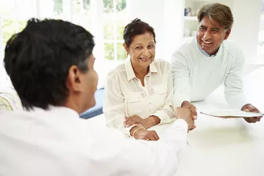 Senior Indian Couple Meeting With Financial Advisor At Home