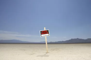 'For sale' sign in dry lake bed