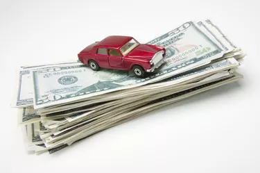 Miniature car on stack of money