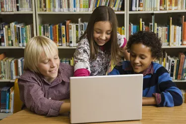 Children in library with laptop computer