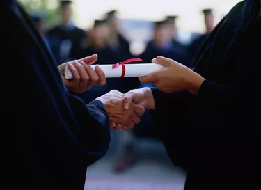 Graduate receiving a diploma, close-up of hands