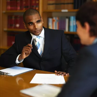 front view of businessman interviewing side view businesswoman sitting