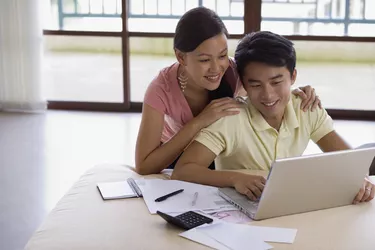 Smiling couple with paperwork and laptop
