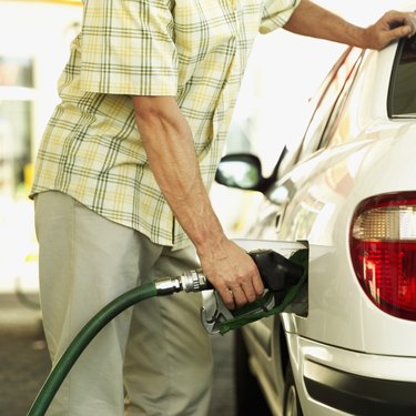 mid section view of a man filling petrol into a car