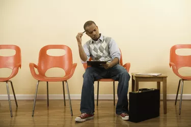 African man filling out form in waiting area