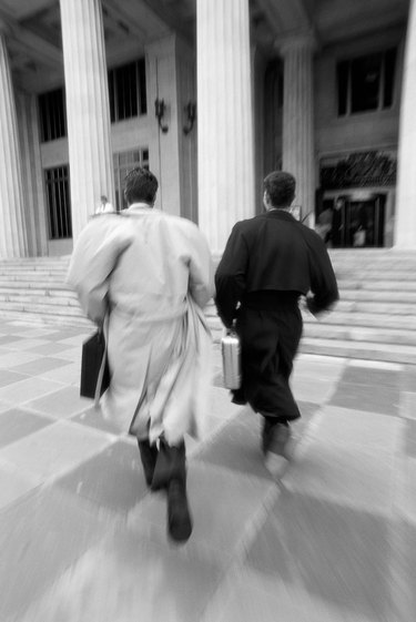 black and white portrait of two young businessmen running