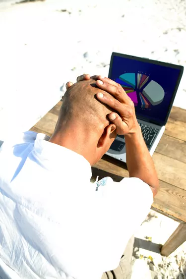 Man with hands on head at computer