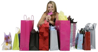 Young Woman Crouching with Shopping Bags and Credit Card