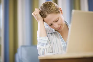 Tired woman with laptop computer