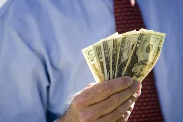 Midsection of a businessman holding American dollars