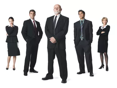 a group of business people line up in a row and look sternly into the camera